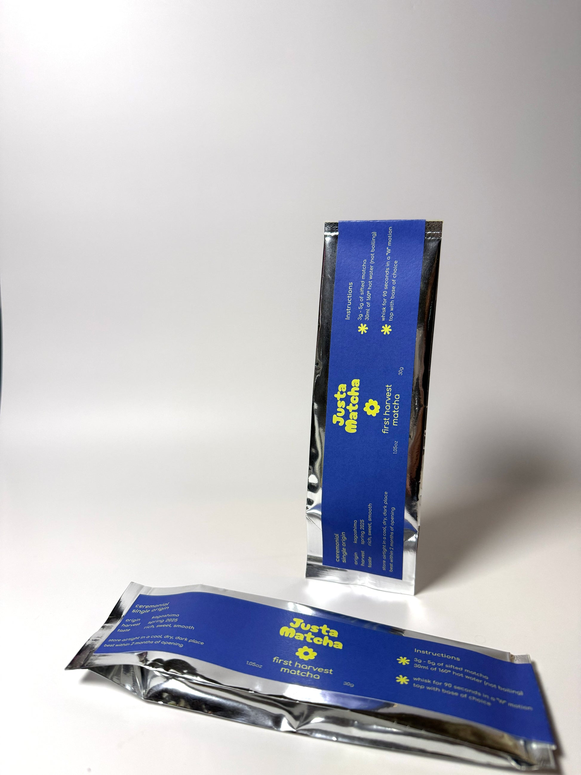 Two blue and silver packages of Justa  Matcha on a white background